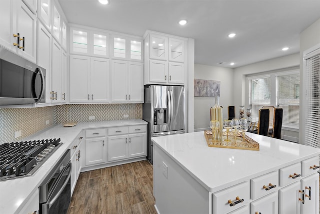 kitchen with white cabinetry, light stone counters, dark hardwood / wood-style flooring, and stainless steel appliances