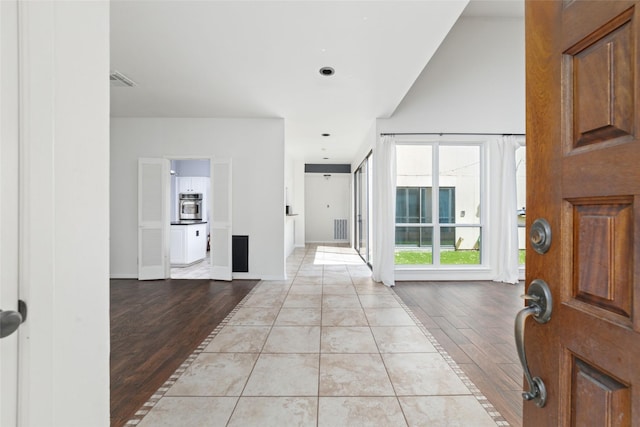 entryway with vaulted ceiling and light hardwood / wood-style floors