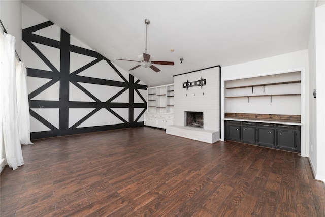 unfurnished living room featuring vaulted ceiling, a brick fireplace, ceiling fan, and dark hardwood / wood-style flooring