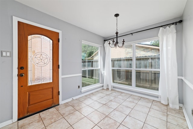 tiled entryway featuring a notable chandelier