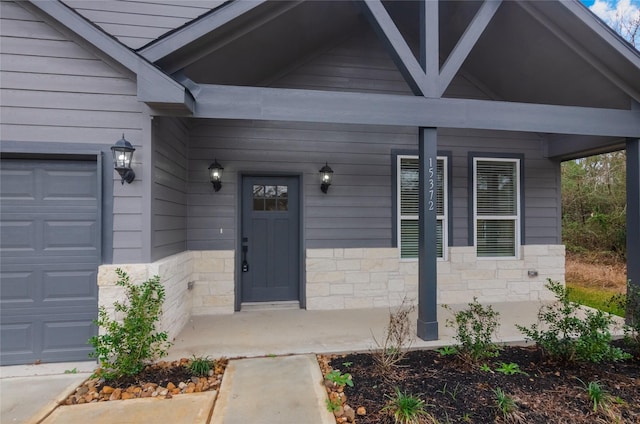 entrance to property with a garage and a porch