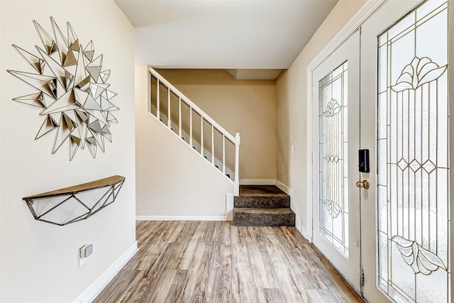 foyer entrance featuring french doors, wood-type flooring, and a wealth of natural light