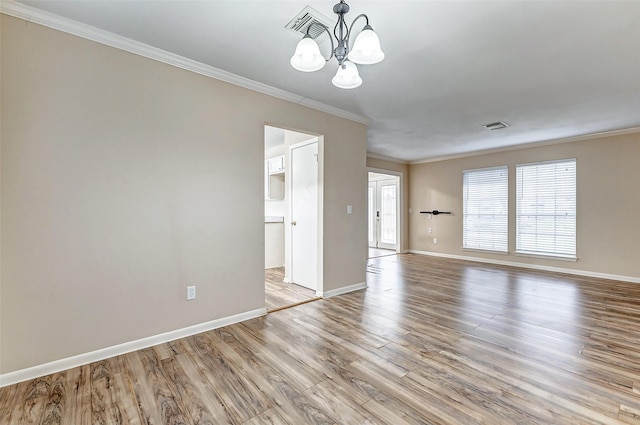 unfurnished room with crown molding, a chandelier, and light hardwood / wood-style floors