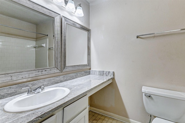 bathroom featuring vanity, walk in shower, and toilet