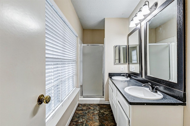 bathroom with vanity, a textured ceiling, and walk in shower