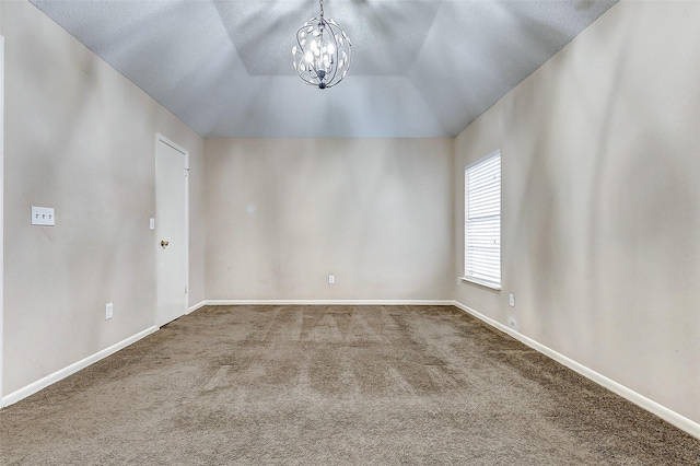 carpeted empty room featuring a chandelier