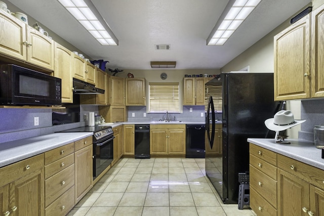 kitchen featuring sink, light tile patterned floors, and black appliances