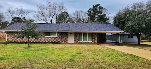 single story home with brick siding, a shingled roof, a carport, driveway, and a front lawn