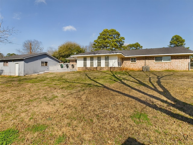 rear view of house featuring a yard and brick siding