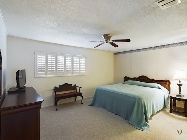 bedroom featuring a textured ceiling, light carpet, a ceiling fan, visible vents, and baseboards