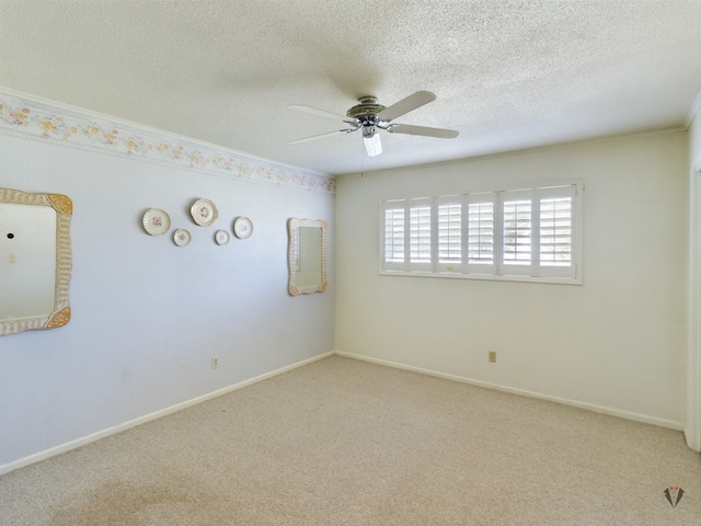 spare room with baseboards, a ceiling fan, light colored carpet, ornamental molding, and a textured ceiling