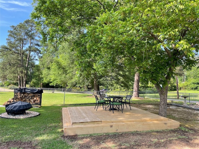 view of yard featuring outdoor dining area, a fenced backyard, and a wooden deck