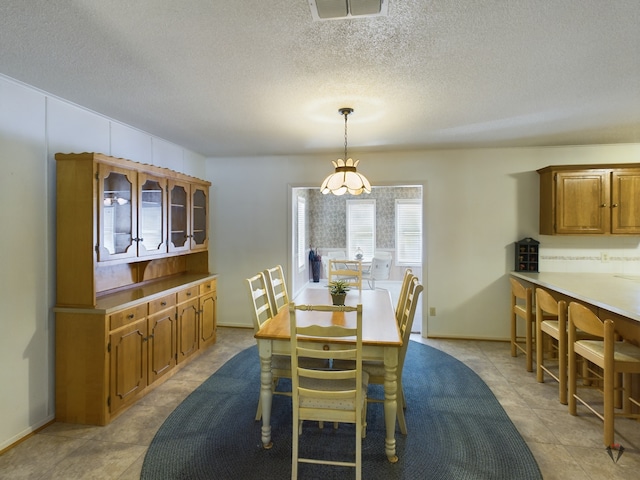 dining space featuring visible vents and a textured ceiling