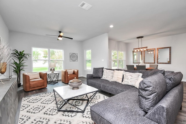 living room featuring wood-type flooring and ceiling fan with notable chandelier