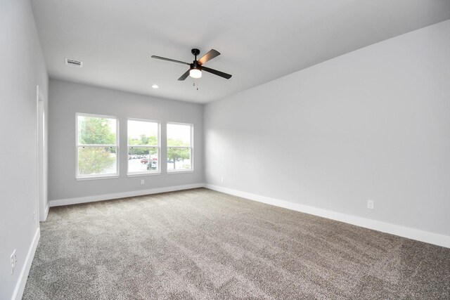 carpeted spare room featuring ceiling fan