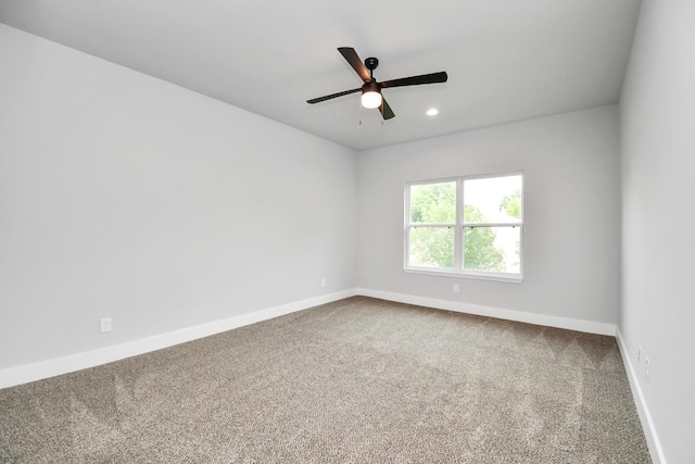 spare room with ceiling fan and carpet