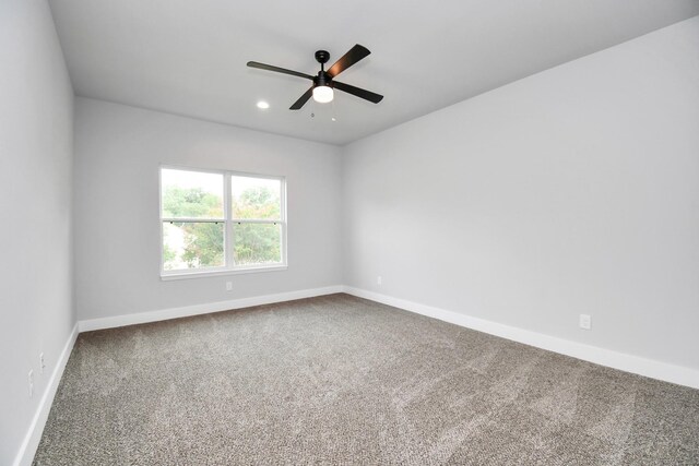 carpeted spare room featuring ceiling fan