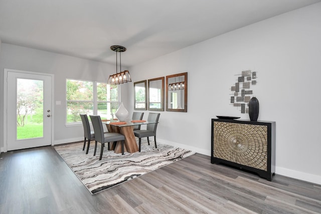 dining space featuring hardwood / wood-style flooring and a chandelier