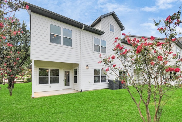 rear view of property with a patio area, central air condition unit, and a lawn