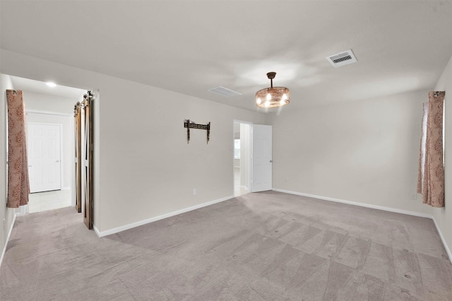 unfurnished room featuring visible vents, light carpet, and baseboards