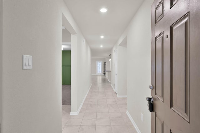 hallway with recessed lighting, baseboards, and light tile patterned floors