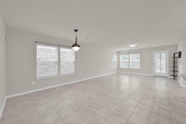 unfurnished room featuring light tile patterned floors, visible vents, and baseboards