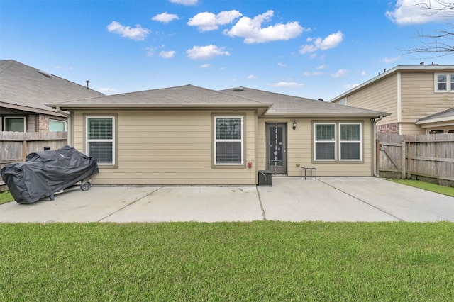 rear view of house with a patio, a lawn, and fence