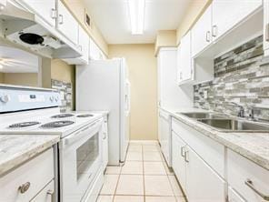 kitchen featuring backsplash, light stone countertops, white cabinets, light tile patterned flooring, and white electric stove