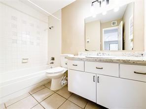 full bathroom with vanity, tiled shower / bath combo, tile patterned floors, and toilet