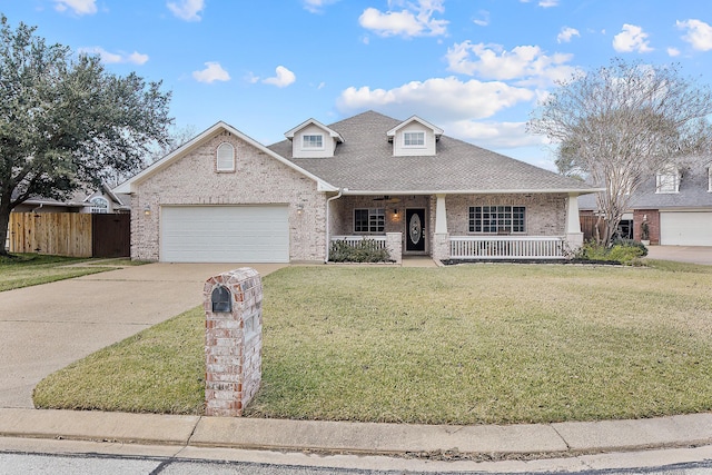 view of property featuring a porch, a garage, and a front lawn