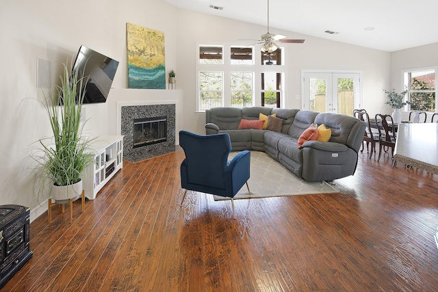 living room featuring dark wood-type flooring, a premium fireplace, ceiling fan, high vaulted ceiling, and french doors