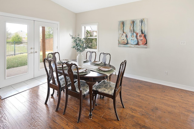 dining area featuring wood-type flooring, lofted ceiling, and french doors