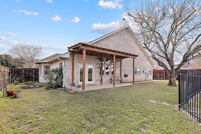 rear view of house with a patio and a yard