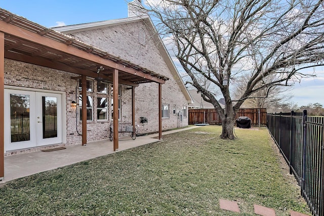 view of yard featuring a patio, french doors, and ceiling fan