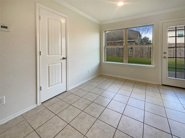 empty room featuring crown molding and light tile patterned floors