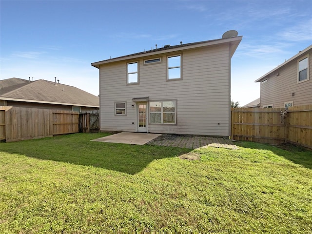 rear view of house featuring a lawn and a patio