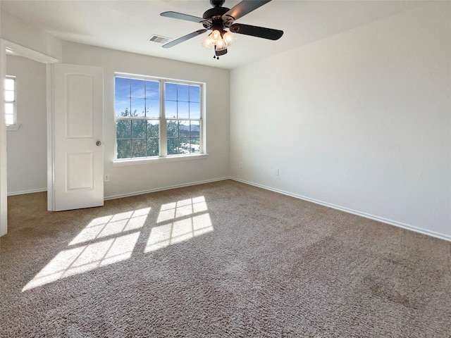 carpeted empty room with a healthy amount of sunlight and ceiling fan