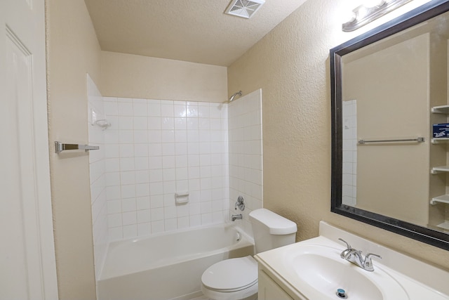 full bathroom with tiled shower / bath combo, vanity, a textured ceiling, and toilet