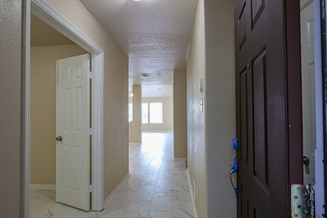 hall with a textured ceiling