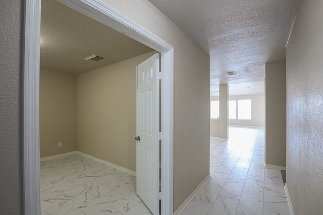 hall with a textured ceiling