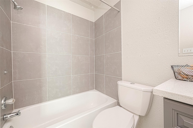 full bathroom with tiled shower / bath, vanity, and toilet