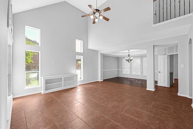 unfurnished living room with a towering ceiling and ceiling fan with notable chandelier