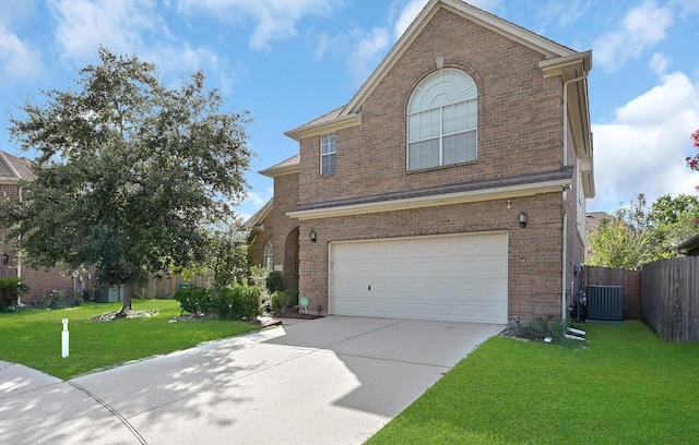 view of front property with central AC unit, a garage, and a front yard