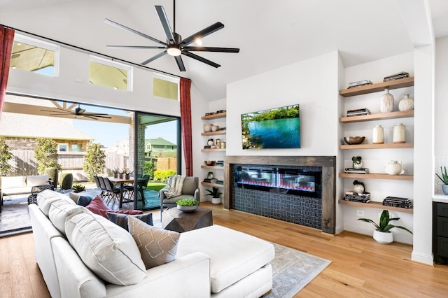 living room featuring light wood-type flooring, built in features, and ceiling fan