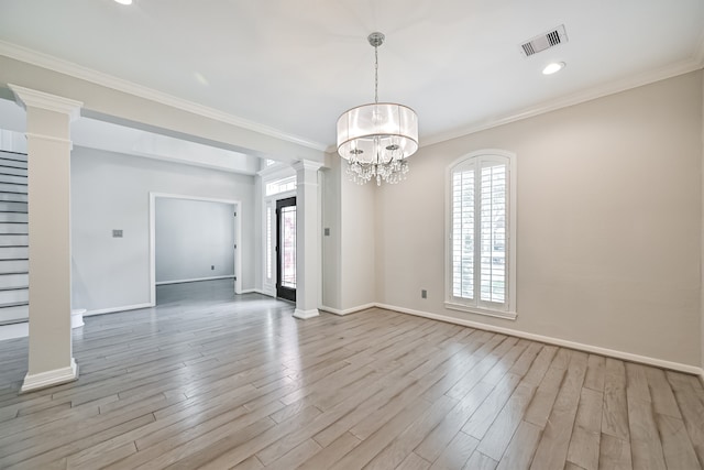 spare room with plenty of natural light, visible vents, decorative columns, and light wood finished floors