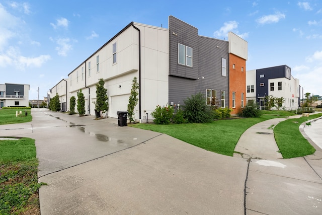 exterior space featuring a garage and a lawn