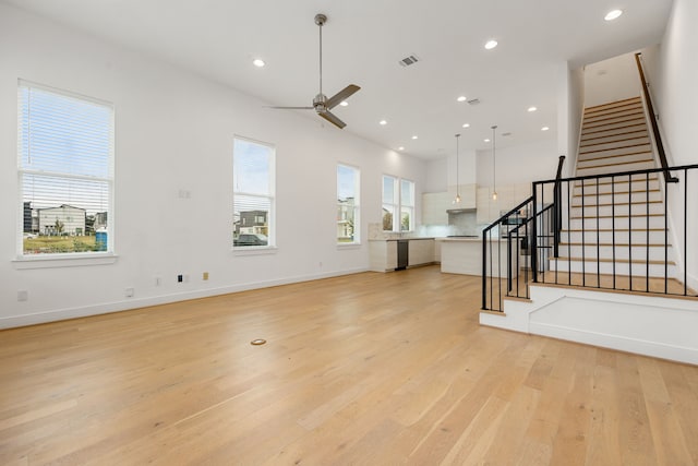 unfurnished living room with ceiling fan and light hardwood / wood-style floors