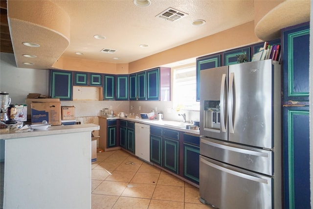 kitchen featuring light tile patterned flooring, blue cabinets, sink, stainless steel fridge with ice dispenser, and white dishwasher