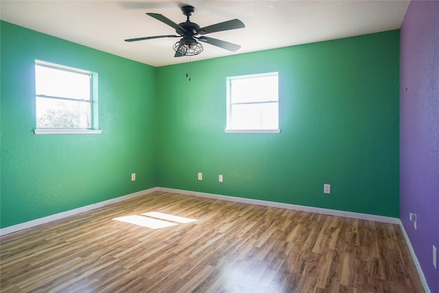 unfurnished room featuring hardwood / wood-style flooring, plenty of natural light, and ceiling fan