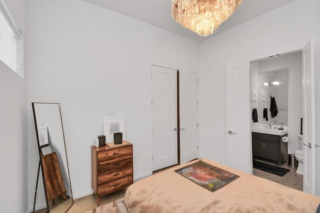 bedroom featuring a notable chandelier and ensuite bath